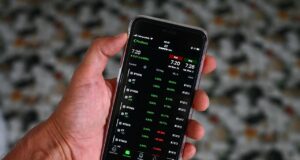 Smartphone s investiční aplikací pro sledování portfolia