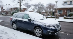 Zaparkované auto v zimě s clonou na skle a zvednutými stěrači